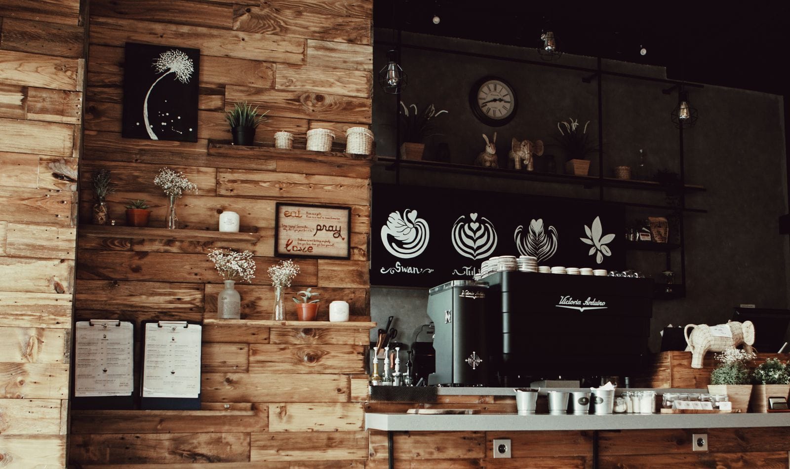 Warm rustic coffee shop interior featuring wooden decor and a professional espresso machine.